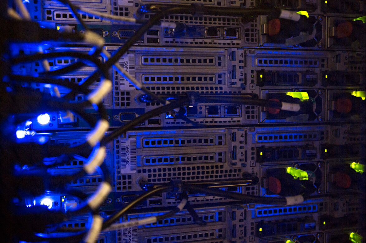 Närbild av ett serverrack med blåa ljus som lyser upp enhetens komponenter