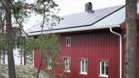 En röd villa med solpaneler på taket