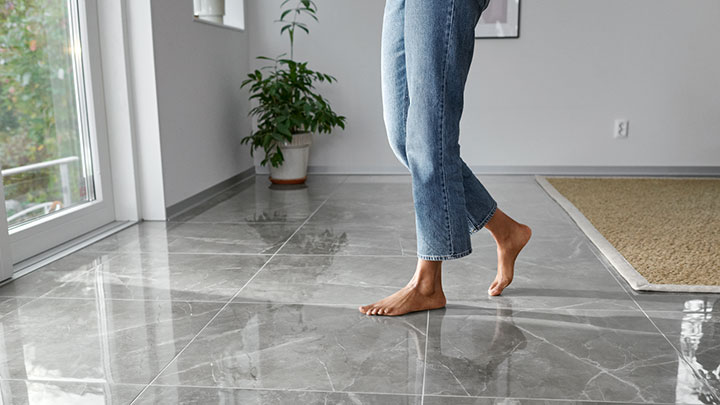 Barfota fötter går på ett stengolv
