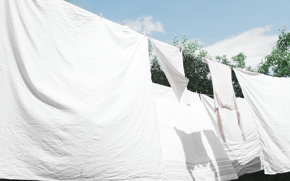 Lakan som torkar utomhus på en tvättlina