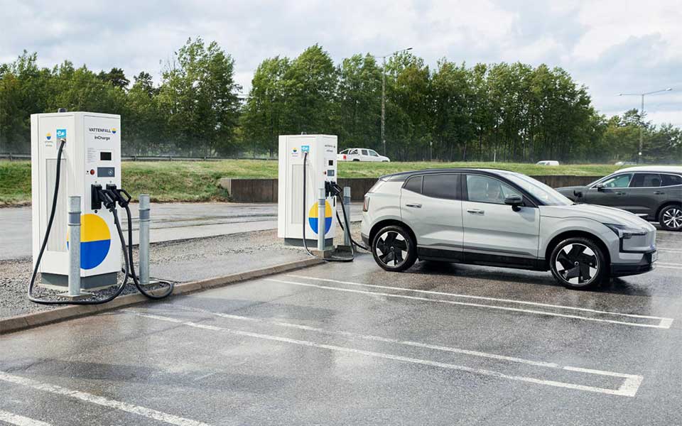 En elbil står parkerad vid en laddstation längs vägen och laddas