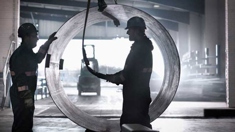 Två industriarbetare framför ett cirkulärt objekt