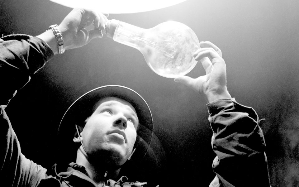 Svårtvit bild på en man som håller i en glödlampa