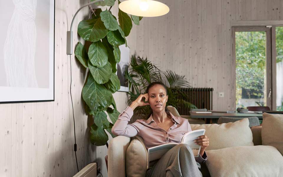 Kvinna som sitter under en lampa och läser