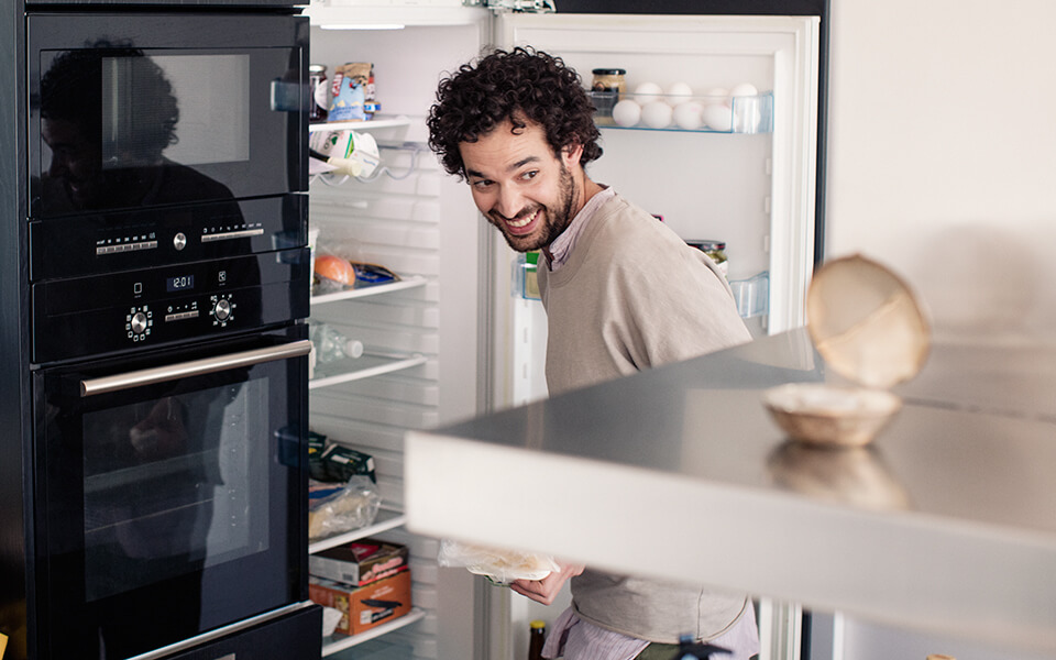 Man vid öppet kylskåp