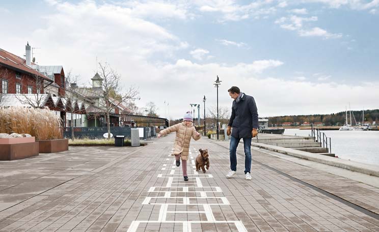 Flicka som hoppar hage på en gågata