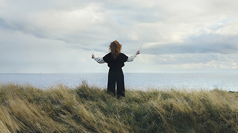 Dirigent ståendes på en klippa