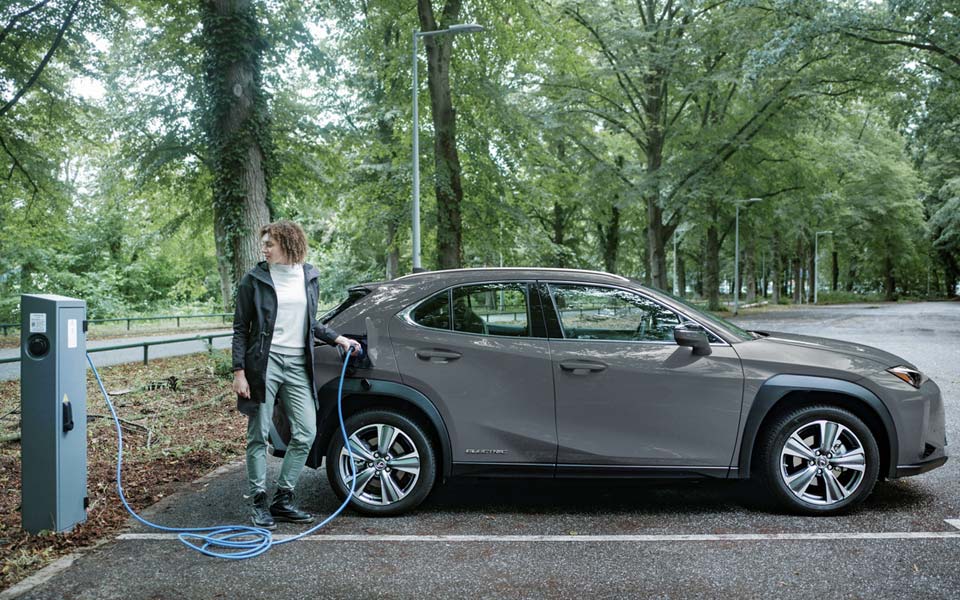 Kvinna som laddar en grå elbil