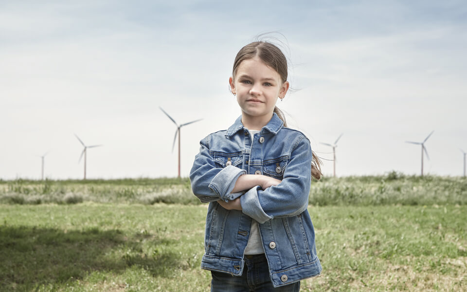 Flicka framför vindkraftverk