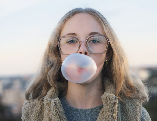 Flicka blåser tuggummi