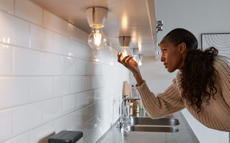 Kvinna som skruvar i en lampa