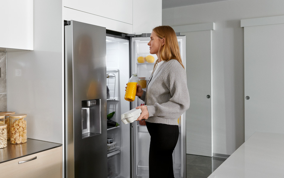 Kvinna som öppnar kylskåp