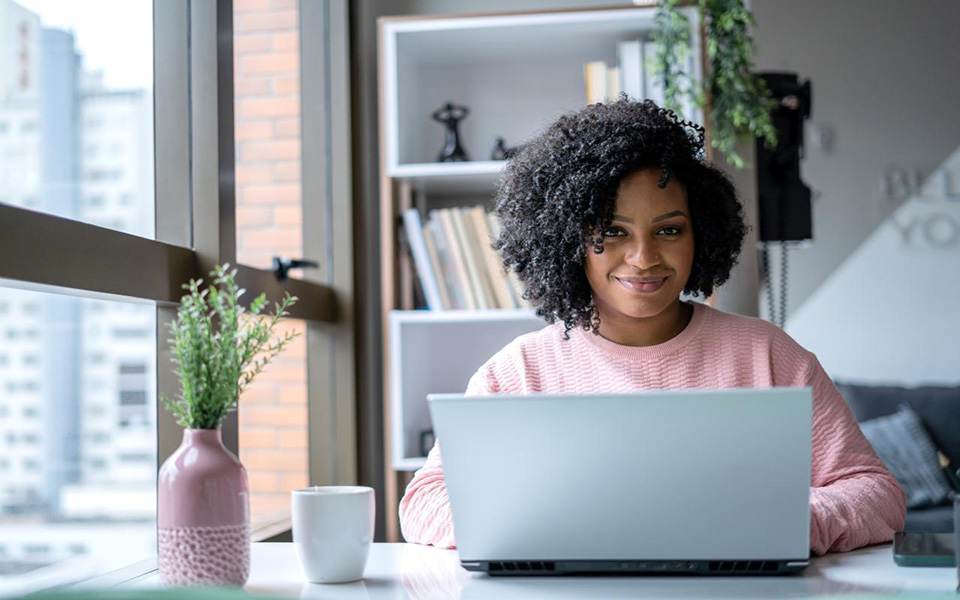 Kvinna som sitter vid en skrivbord och arbetar med en laptop i en ateljé