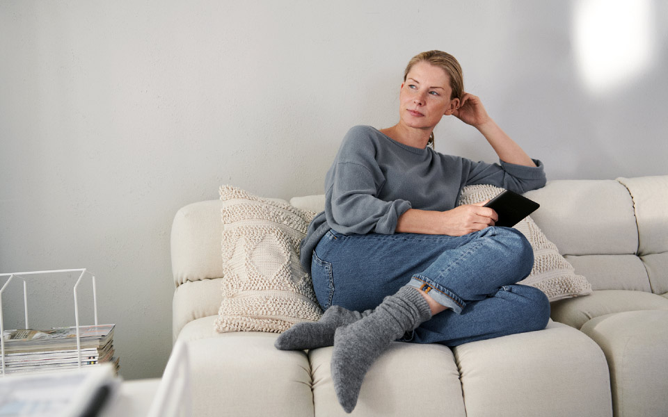 Kvinna som kopplar av i soffan i vardagsrummet