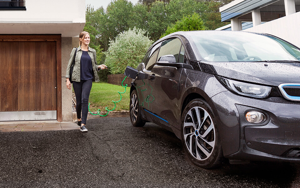 Elbil som laddas på garageuppfart