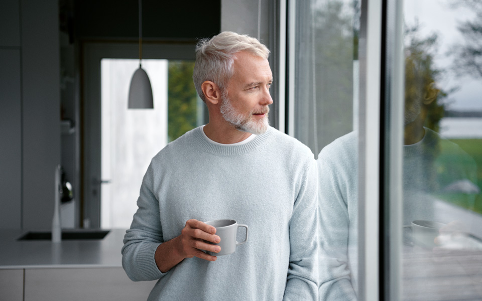 Man som står vid fönster