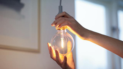 Händer som byter en glödlampa