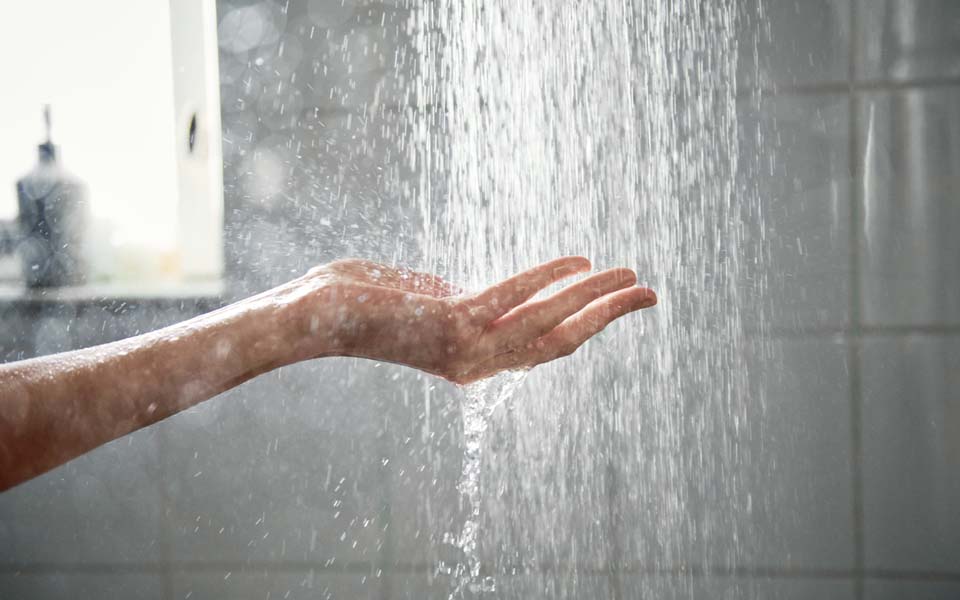En hand som sticks in i en duschstråle