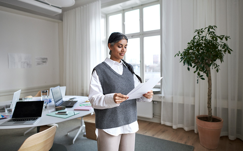 Kvinna på kontor håller i ett papper.