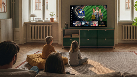 En familj sitter i vardagsrummet och kollar på TV.