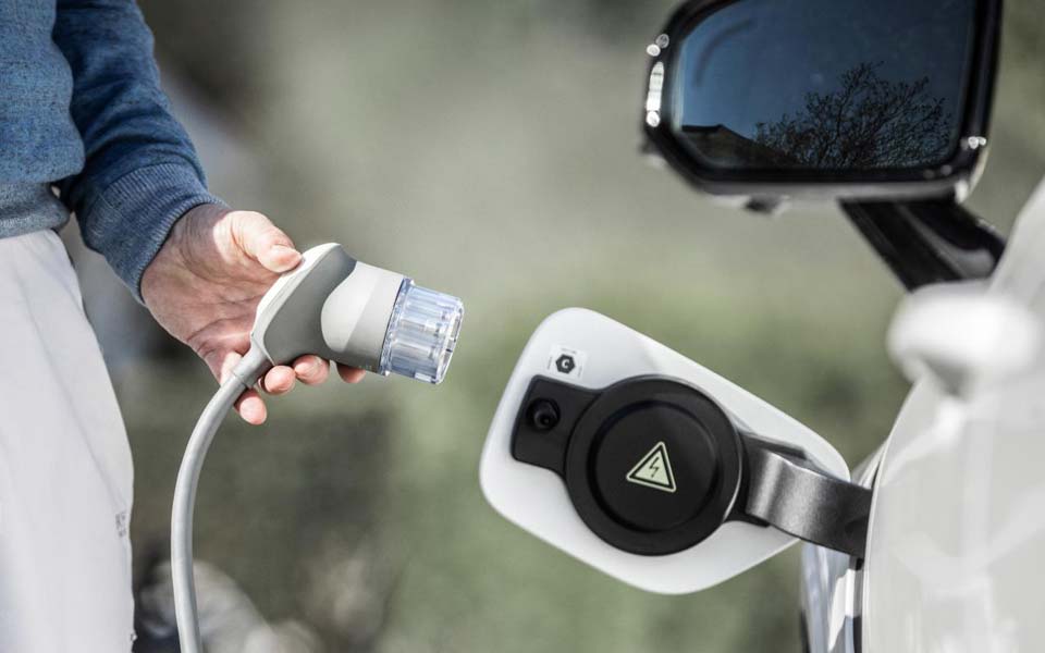 Man som laddar en elbil