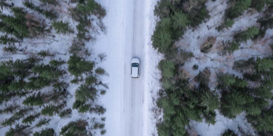 En bil som kör genom ett vintrigt landskap