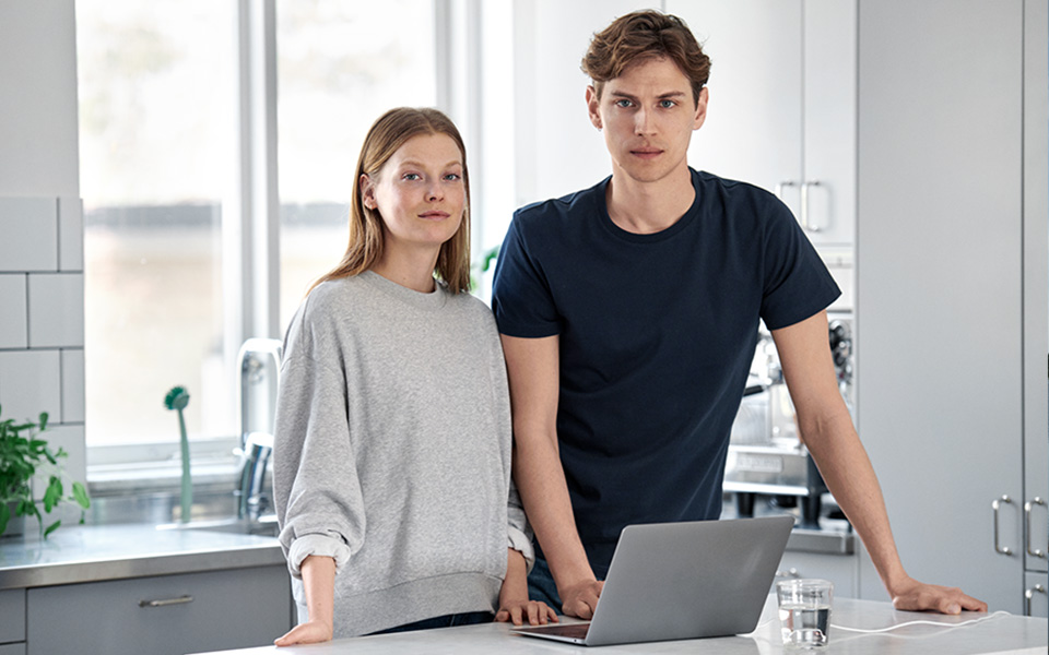 Kvinna och man i köket vid laptop