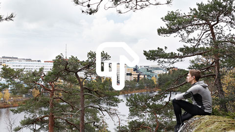 Bild på joggare som vilar i skogen och blickar ut över en stad