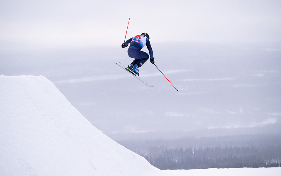 Skidåkare som hoppar i en skidbacke.