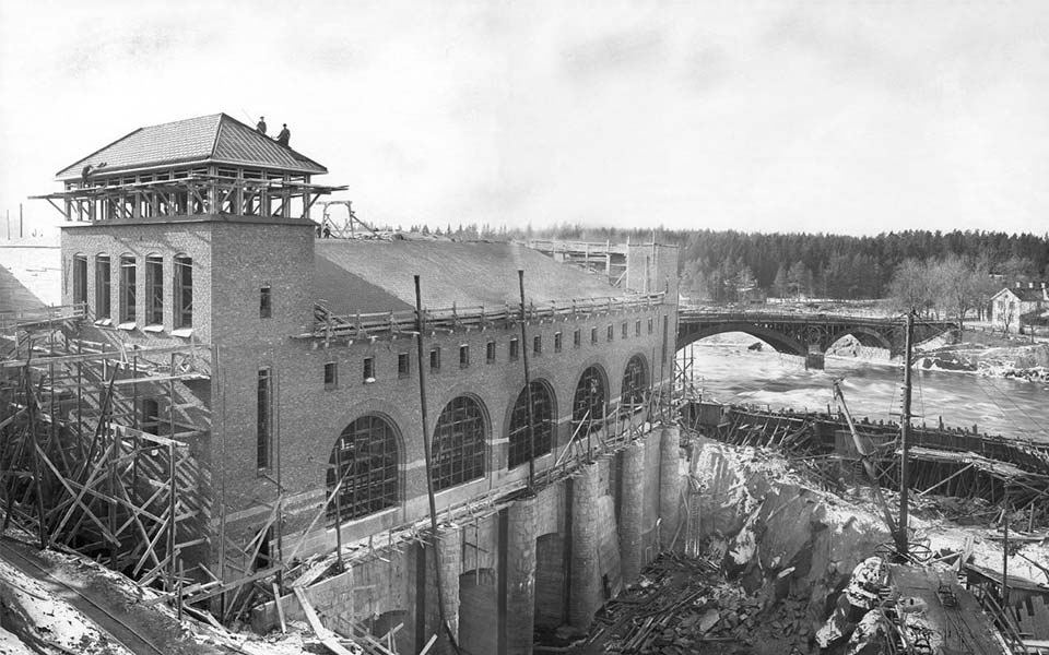 Ett vattenkraftverk under uppförande i Älvkarleby, med damm och forsande vatten som visar vattenkraftens tidiga roll i Sveriges elektrifiering.