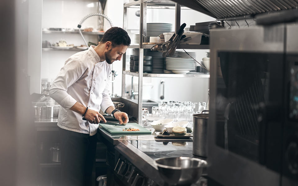 Kock som förbereder mat i ett restaurangkök