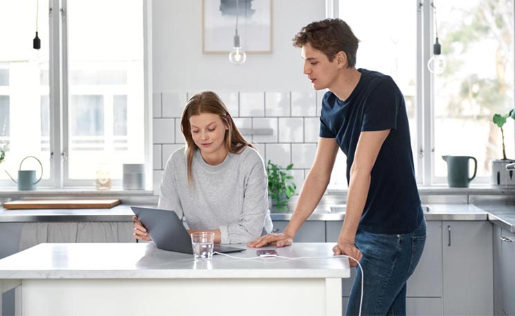 Man och kvinna som står vid en laptop i ett kök