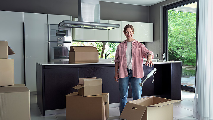 Kvinna som flyttpackar i ett kök