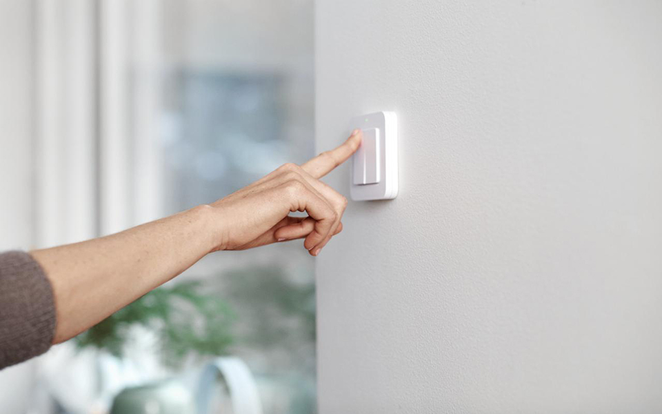 Pekfinger trycker på en väggkontakt