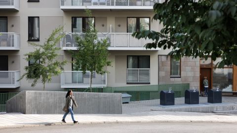 Kvinna på avstånd promenerar i ett bostadskvarter