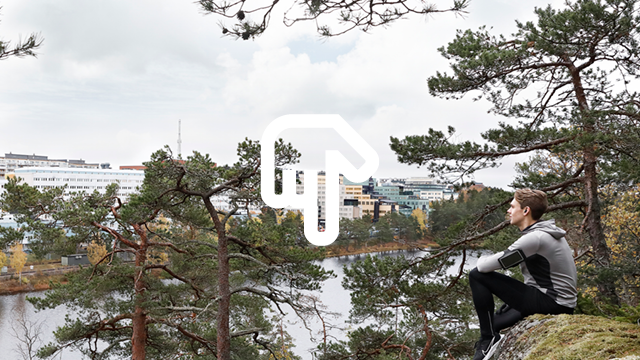 Bild på joggare som vilar i skogen och blickar ut över en stad