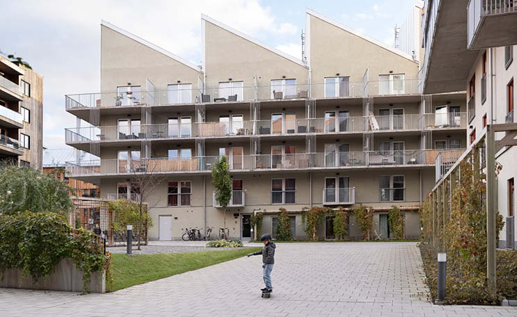 Pojke åker skateboard på innergården till ett flerfamiljshus