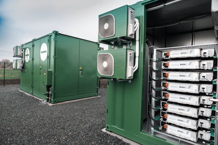 Närbild på ett batterilagringssystem i gröna containrar utomhus.