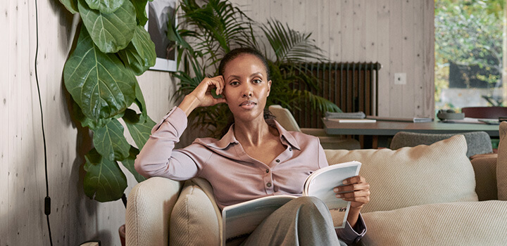 En kvinna sitter i en fotölj och läser