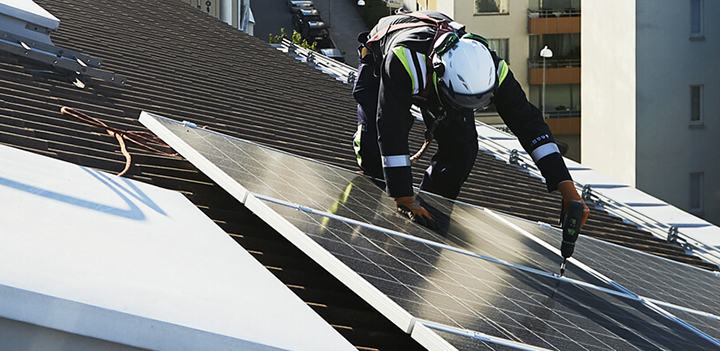 En solcellsinstallatör på ett tak 