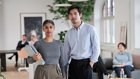 Man och kvinna på ett kontor som står bredvid varandra