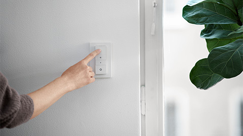 En hand stänger av en lysknapp.