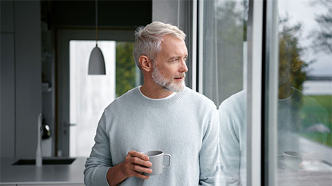 Man som tittar ut genom ett fönster