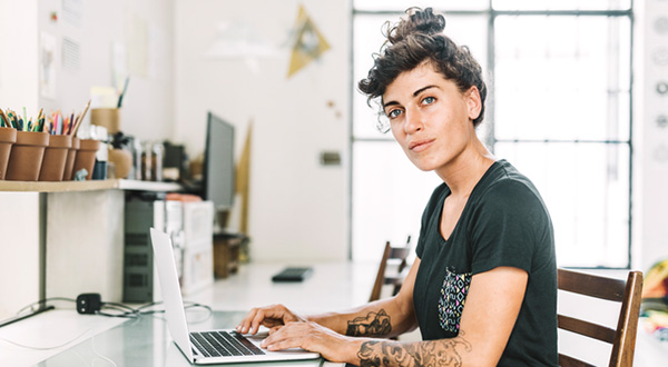 En kvinna sitter vid en laptop