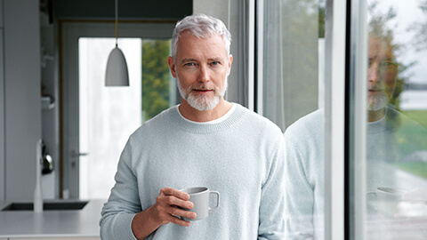 En man står vid förstret och tittar år kameran.