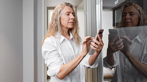 En äldre kvinna kollar sin värmepump