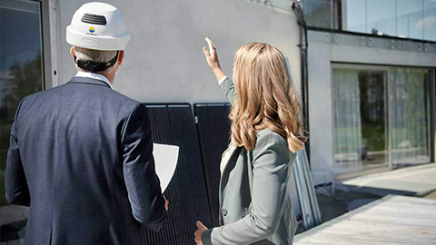 En man och kvinna står framför ett hus.