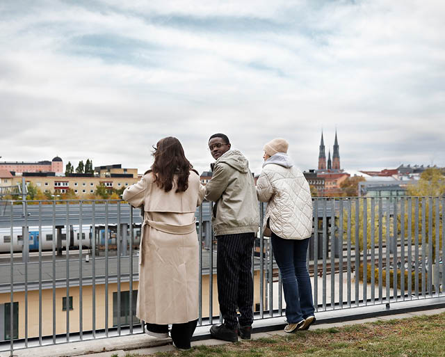 Tre ungdomar blickar ut över Uppsalas stadskärna