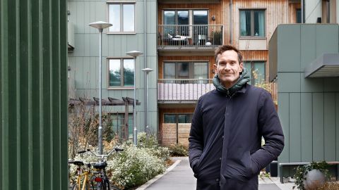 Man som står på en innergård i ett bostadsområde