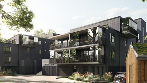 Nybyggda bostadshus i mörk kulör och trämaterial